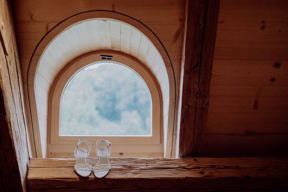 Braut beim Ankleiden, Hochzeitsfotografin hält emotionale Vorbereitungen für den Hochzeitstag fest.